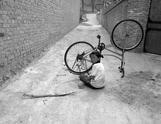 阳石村一少年在拆卸自行车玩耍1